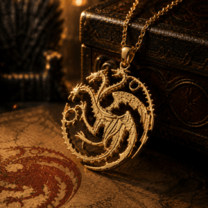 Premium gold House of the Dragon-inspired three-headed dragon pendant necklace displayed on a fantasy-themed book with dragon emblem, dragon figurine, and medieval map background.